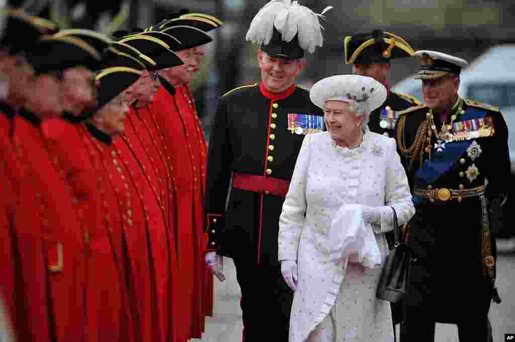 Britain's Queen Elizabeth II, center, and Prince Philip, right, arrive at Chelsea Pier in London, before boarding the royal barge to participate in the Diamond Jubilee River Pageant, June 3, 2012.