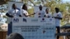 Namandingo - right - holds hands with Queen Elizabeth Central Hospital Deputy Director Linley Chewere. 