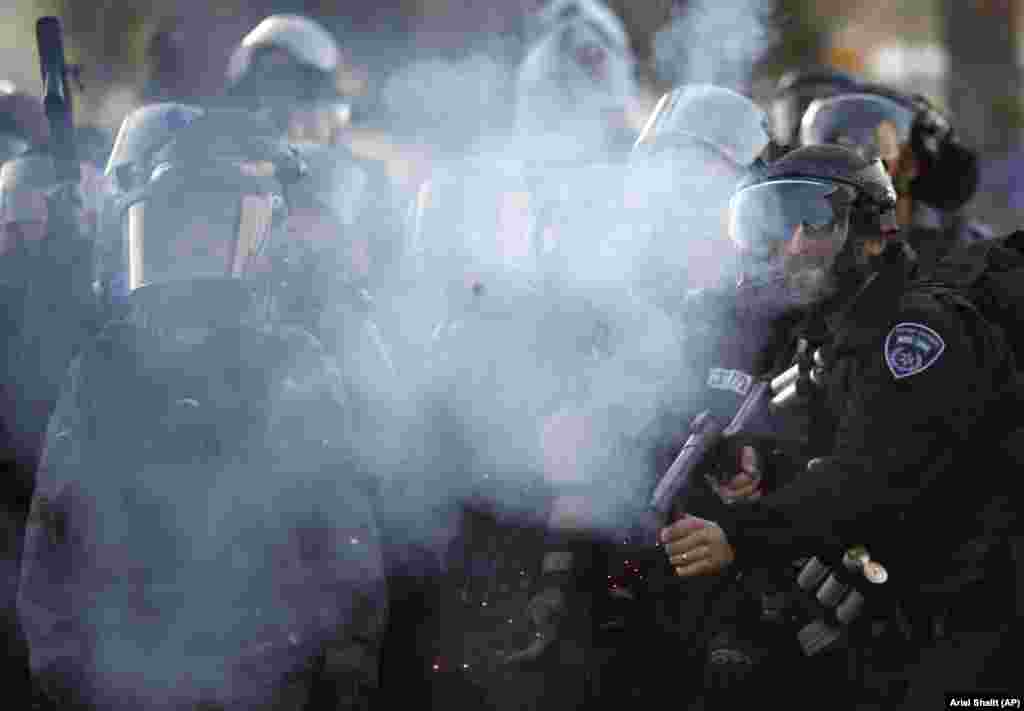 Israeli riot police fire tear gas at Israeli Arab and Palestinians activists during a protest against the Prawer Plan plan to resettle Israel’s Bedouin minority from their villages in the Negev Desert, in the village of Arara.