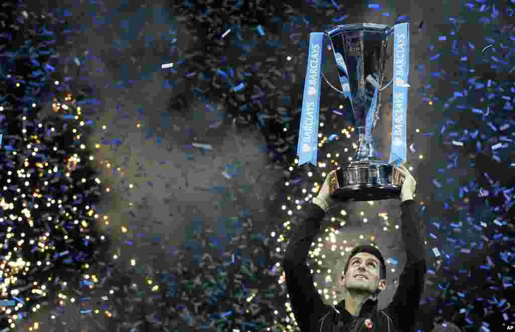 Petenis Serbia, Novak Djokovic mengangkat trophy 'ATP World Tour Finals' setelah mengalahkan petenis Spanyol, Rafael Nadal di London, Inggris.