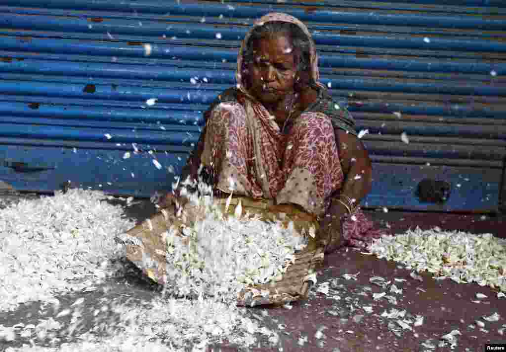 Seorang buruh perempuan India mengupas bawang putih di sebuah pasar grosir di Kolkata.