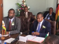 Umholi webhanga leAfrican Development Bank, uMnu. Damoni Kitabire, loMnu. Mthuli Ncube obona ngezemali kuhlangothi lukahulumende.
