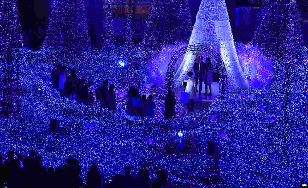 Warga menonton pertunjukan Iluminasi Cahaya "Blue Canyon" pada 'Caretta Illumination' di Tokyo, Jepang.