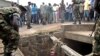 FILE - A man begs for help from the military as he stands in a drain where he had hidden to escape a lynch mob at the Cibitoke district of Burundi's capital, Bujumbura. International judges have approved the opening of a full investigation into alleged crimes against humanity in Burundi, where at least 1,200 people have died in unrest since 2015.