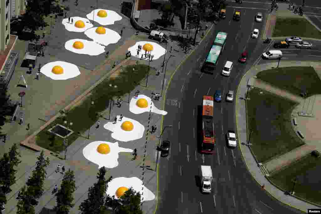 Karya seni berbentuk telur-telur matasapi terlihat di jalanan pada festival seni di kota Santiago, Chile.