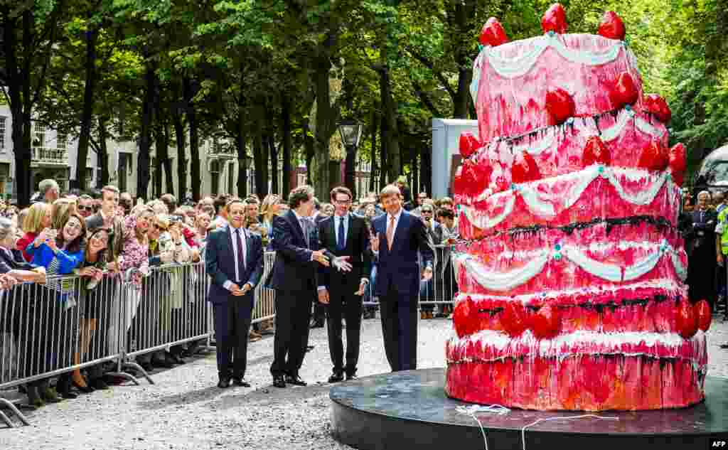 Raja Belanda Willem-Alexander (kanan) dan seniman Vincent Olinet (tengah) menghadiri pembukaan pameran seni patung di Den Haag, Belanda.