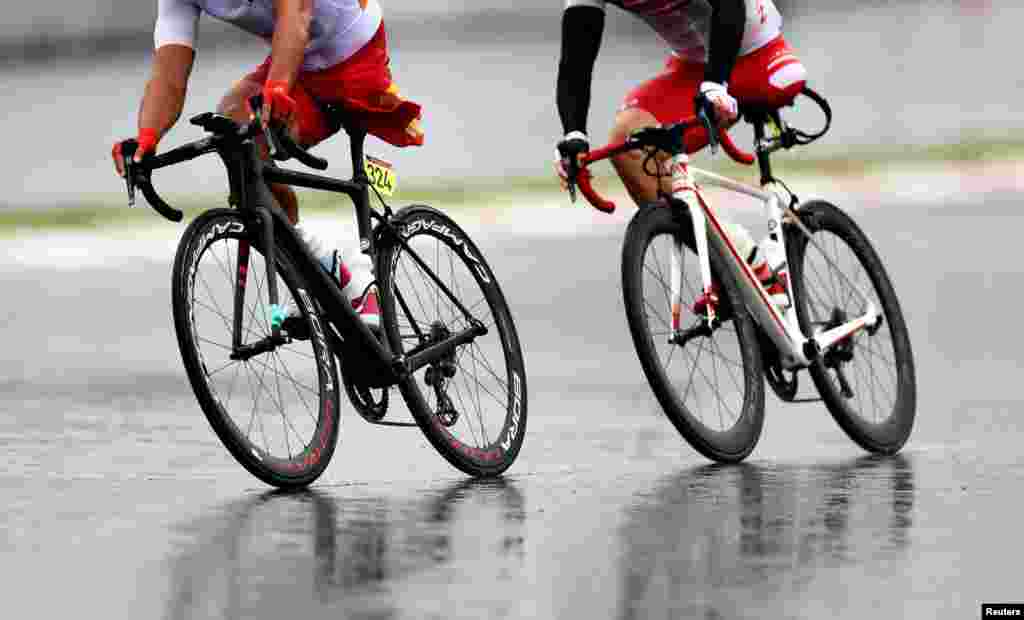 Guihua Liang of China and Shota Kawamoto of Japan compete in the men&#39;s cycling road C1-3 at the Fuji International Speedway during the&nbsp;Tokyo 2020 Paralympic Games in Oyama, Japan.