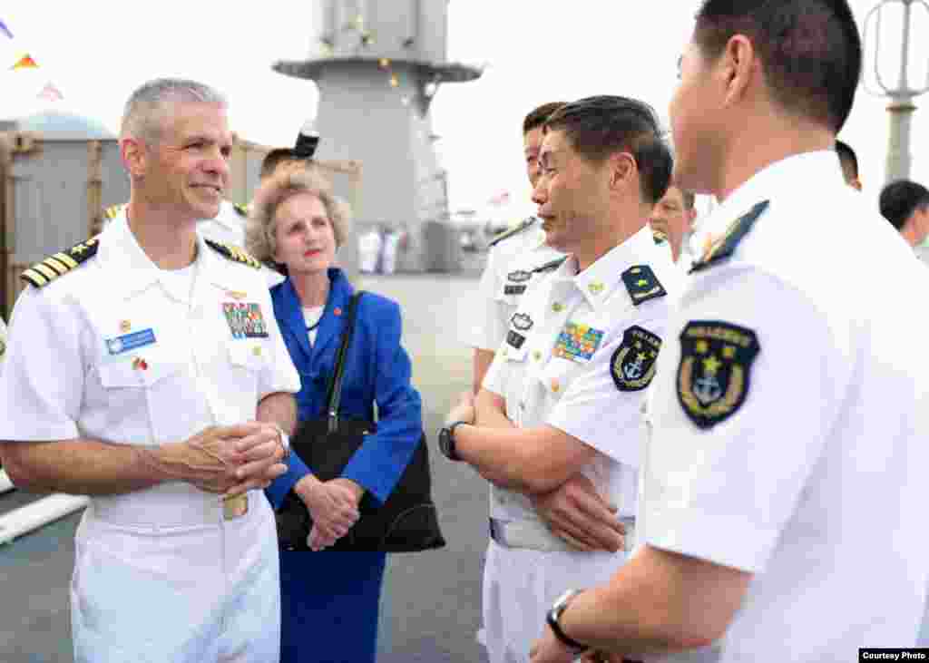 美国第七舰队旗舰“蓝岭号”在湛江进行港口访问,“蓝岭号”指挥官凯尔·希金斯上校与中国人民解放军海军中将沈金龙一起参观军舰 (2015年4月21日)。2017年1月,广州军区副司令员兼南海舰队司令沈金龙升任海军司令。