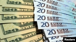 Archivo - Euros y dólares.