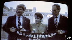 资料照片：电视画面显示，来自加州的民主党众议员南希·佩洛西(中)、来自乔治亚州的民主党众议员本·琼斯(左)和来自华盛顿州的共和党众议员约翰·米勒在天安门广场展示横幅，“献给为中国民主事业牺牲之烈士。”(1991年9月4日)
