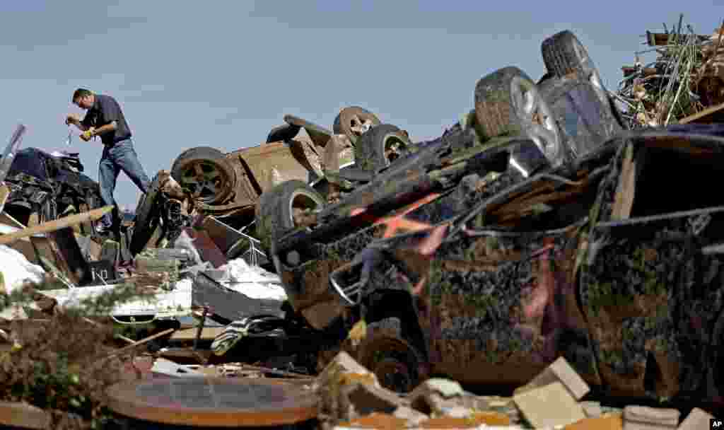 Pegawai perusahaan asuransi Farmers Insurance, Paul Gaipo, melihat mobil-mobil yang rusak karena tornado di sebuah mal yang hancur di Moore, Oklahoma (22/5).
