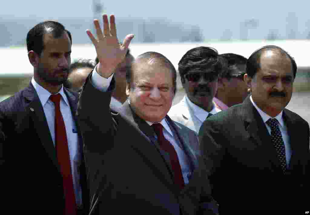 Perdana Menteri Pakistan Nawaz Sharif melambaikan tangannya saat tiba di New Delhi untuk menghadiri upacara pelantikan perdana menteri India Narendra Modi (26/5). (AP/Saurabh Das)