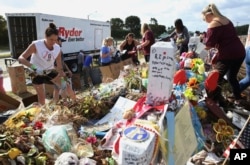 Volunteers, students and parents sort items left at the memorial site for the 17 students and faculty killed at Marjory Stoneman Douglas High School, March 28, 2018 in Parkland, Florida. Flowers and plants will be composted while all other items will be c
