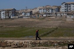 A North Korean boy walks along a path in front of a village on a road south of Kaesong, North Korea, April 24, 2013.