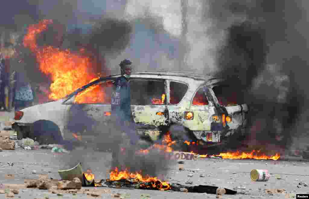 A protester looks on near a burning barricade during a "national shutdown" against the election outcome, in Maputo, Mozambique.