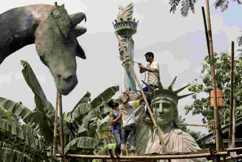 Para pekerja membangun replika Patung Liberty (Statue of Liberty) di sebuah bengkel kerja di Jakarta, Indonesia.