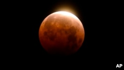 Light shines from a total lunar eclipse over Santa Monica Beach in Santa Monica, Calif., Wednesday, May 26, 2021. (AP Photo/Ringo H.W. Chiu)