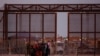 Migrantes se reúnen cerca del muro fronterizo después de cruzar el río Bravo con la intención de entregarse a los agentes de la Patrulla Fronteriza de Estados Unidos para solicitar asilo, visto desde Ciudad Juárez, México, el 22 de octubre de 2023.