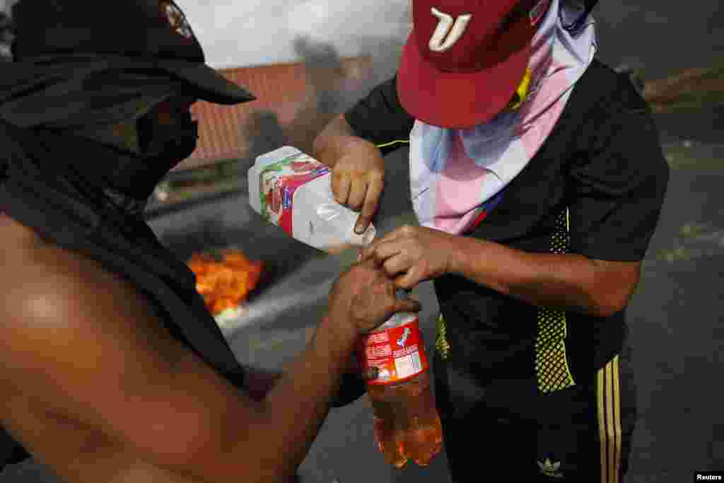 Demonstrators fill a bottle with gasoline during protests against Nicolas Maduro's government in San Cristobal, about 660 km southwest of Caracas, Feb. 26, 2014. 