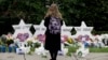 A person stands in front of Stars of David that are displayed in front of the Tree of Life Synagogue with the names of those killed in Saturday's shooting in Pittsburgh, Oct. 29, 2018.
