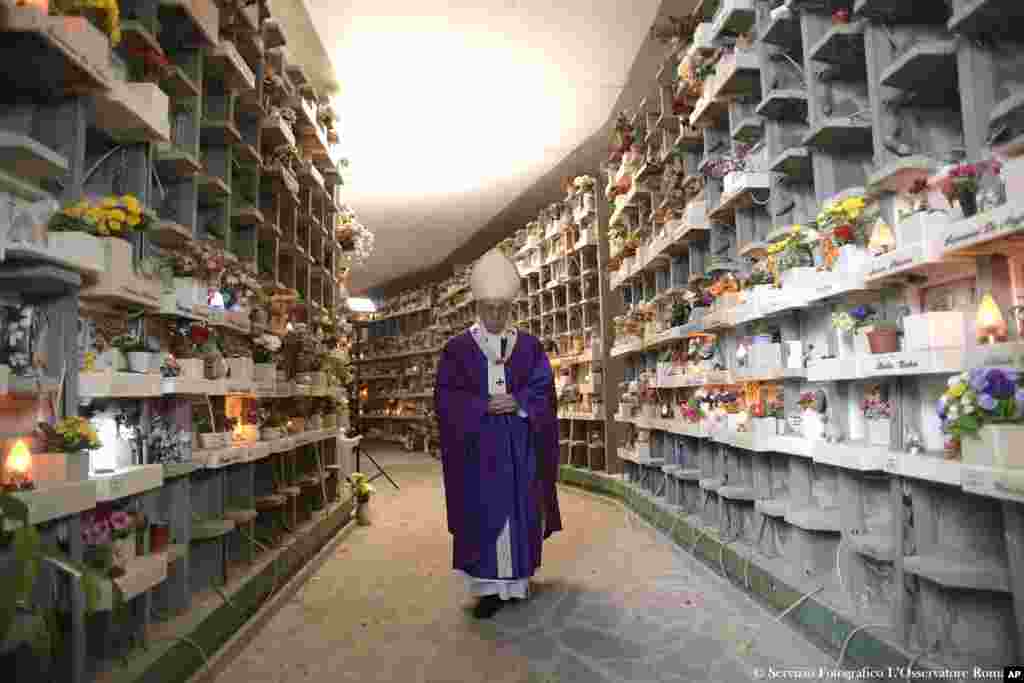 Pope Francis walks past graves at the Prima Porta Cemetery in Rome, Italy, to celebrate a Mass on the occasion of All Souls' Day.