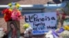 Unas flores y una imagen de la Virgen de Guadalupe adornan un monumento conmemorativo improvisado en honor de las víctimas de un tiroteo en un centro comercial en El Paso, Texas, el domingo 4 de agosto de 2019. El letrero dice: "El Paso es una familia. Permanecemos unidos".