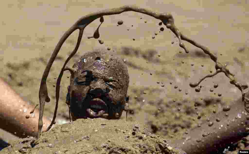 Seorang pria bermandikan pasir ketika warga Afrika Selatan merayakan hari pertama tahun baru di pantai Durban, Afrika Selatan.