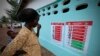Seorang perempuan dan anak-anak melihat poster-poster pencegahan Ebola di sebuah sekolah Toulepleu di barat Pantai Gading, 4 November 2014. (Foto: Thierry Gouegnon/Reuters) 