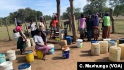Women wait to collect water at a borehole in Zimbabwe’s Tsholotsho District, April 18, 2019.