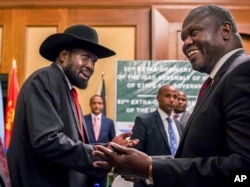 FILE - In this file photo dated June 21, 2018, South Sudan's President Salva Kiir, left, and opposition leader Riek Machar, right, shake hands during peace talks in Addis Ababa, Ethiopia.