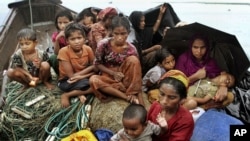 Rohingya Muslims who fled Myanmar to Bangladesh to escape religious violence, sit in a boat after being intercepted crossing the Naf River by Bangladeshi border authorities in Taknaf, Bangladesh, June 13, 2012.