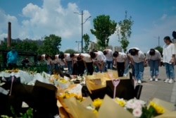 河南郑州市民在地铁5号线站台前给洪灾死难者献上鲜花，鞠躬致哀。（2021年7月27日）