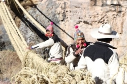 Members of the Huinchiri community rebuild an Incan hanging bridge, known as the Qeswachaka bridge, using traditional weaving techniques in Canas, Peru, June 13, 2021.