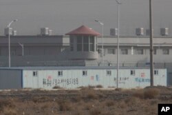 2018年12月3日在中国新疆昆山工业园区的一个设施周围，有警卫塔和铁丝网。 这是新疆的拘禁营地之一。