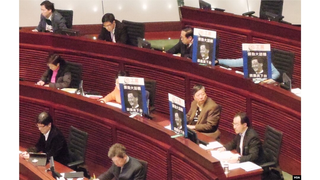 多位泛民主派立法會議員在座位上展示標語，諷刺特首梁振英說謊，要求他下台