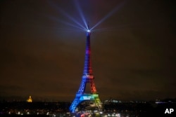 FILE - The Eiffel Tower is lit with colors for the Paris 2024 bid during the launch of the international campaign of the French capital as candidate for the 2024 Olympic summer games, in Paris, France, Feb. 3, 2017.