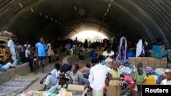 Families displaced by fighting in South Sudan camp in a warehouse inside the United Nations Mission in Sudan facility in Jabel, on the outskirts of Juba, Dec. 23, 2013.