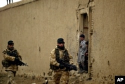 Arhiva - Britanski vojnici iz međunarodne koalicije predvođene NATO-om patroliraju dok ih avganistanska deca posmatraju u Kabulu, Avganistan, 27. januara 2006.