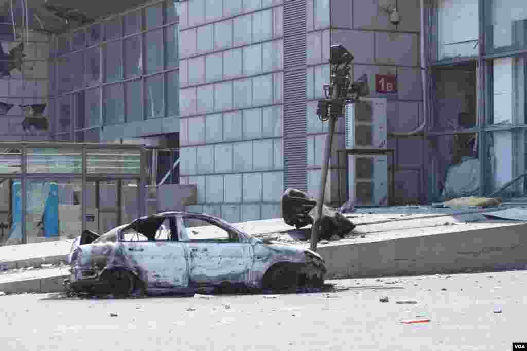 天津爆炸事故现场，核心爆炸区周围多座居民楼窗户被震碎，高速公路桥梁受损，多辆大货车被炸翻，小汽车起火或被砸，多名当地居民仍逗留在事故现场。（美国之音记者东方拍摄）