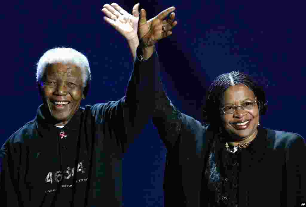 Mantan Presiden Afrika Selatan Nelson Mandela (kiri) dan istrinya Graca Machel, melambaikan tangan kepada para hadirin saat menghadiri konser "Live 8" di Johannesburg, Afrika Selatan, 2 Juli 2005.