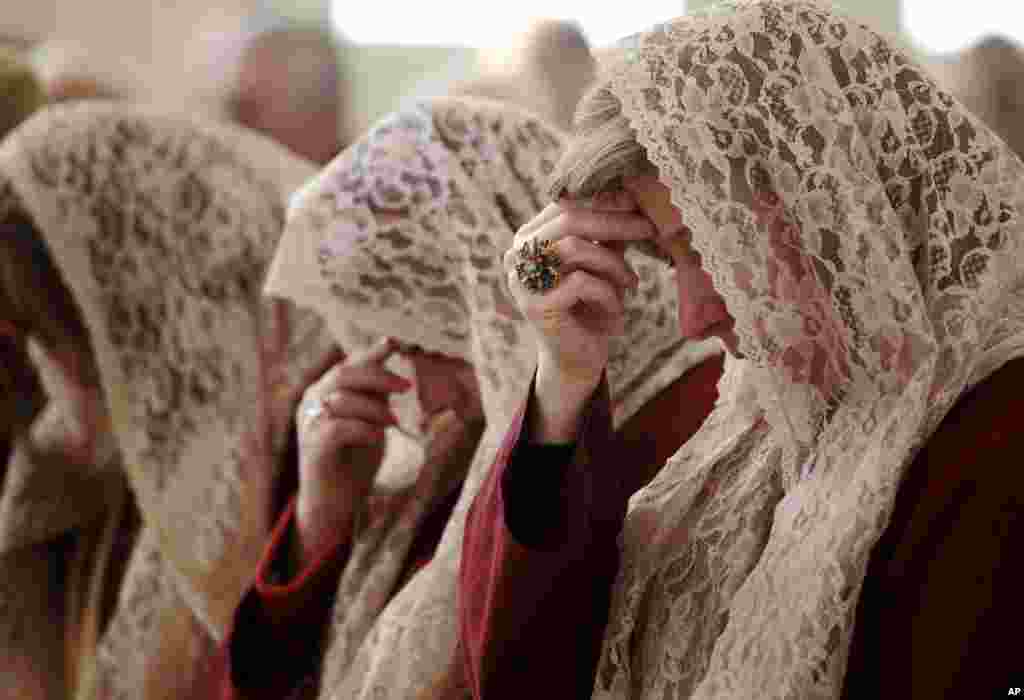 Para perempuan dari gereja Orthodox Suriah, Saint Afram, melakukan doa pada pagi hari di hari Natal di kota Amman, Yordania.