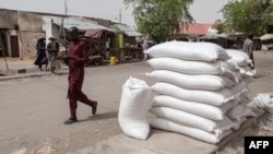FILE - People walk on a street in the town of Damasak, northeast Nigeria, April, 25 2017. Three facilities belonging to international aid partners were targeted in the town Sunday.