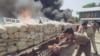 Burmese narcotic control officials put more wood to burn some six tons of seized opium, heroin and other drugs before diplomats, journalists and international business leaders in Rangoon, Burma. (File Photo)