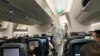 FILE - A worker in a hazardous materials suit takes the temperature of a passenger on a Cathay Pacific flight from Hong Kong to Rome after it landed at Rome Fiumicino Airport in Rome, Italy, Jan. 31, 2020.