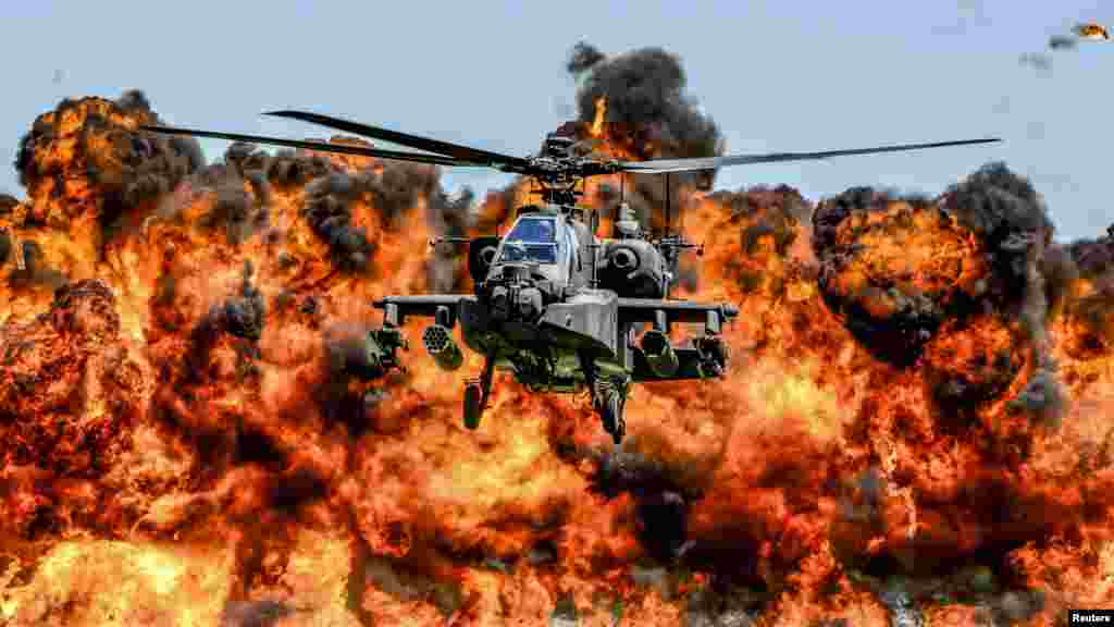Sebuah helikopter Apache AH-64D terbang di antara kobaran api pada latihan garda nasional negara bagian South Carolina.