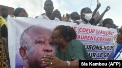 Un partisan de l'ancien président ivoirien Laurent Gbagbo, fondateur du Front populaire ivoirien (FPI), embrasse son portrait sur une banderole à Abidjan, le 31 août 2020.