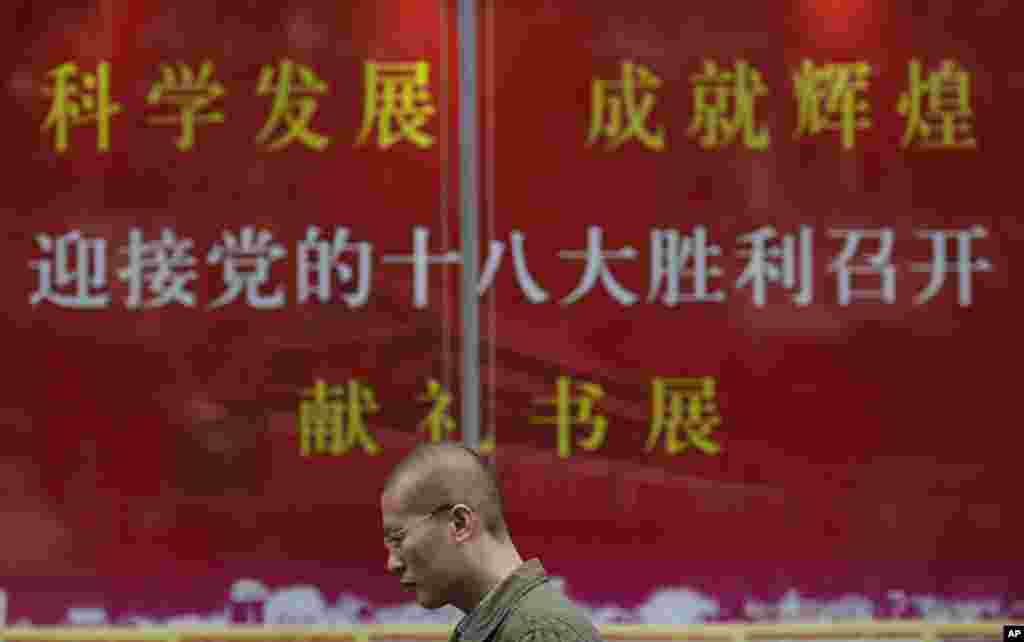 2012年11月8日,中共18大在北京召开。在上海,一位男士走过上海某书店迎接18大官方的宣传招贴。
