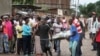 Men carry a body in the Nyakabiga neighborhood of Bujumbura, Burundi, where a number of people were found shot dead a day after the government said an unidentified group had carried out attacks on three military installations, Dec. 12, 2015.