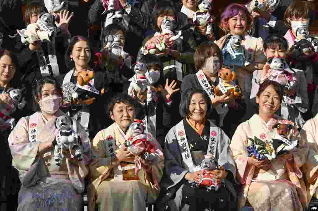 Owners of Sony&#39;s pet robot Aibo pose for a commemorative photo during an event to celebrate Aibo&#39;s third birthday and wish for good health in the future at Kanda shrine in Tokyo.
