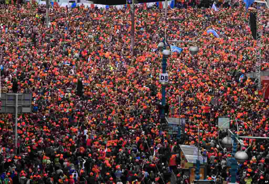 Rakyat Belanda berkumpul di Alun-Alun Dam untuk menyaksikan Raja Belanda Willem-Alexander, Ratu Maxima dan Putri Beatrix menandatangani akte pengunduran diri di Istana Kerajaan di Amsterdam (30/4).